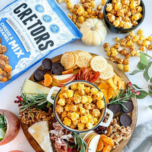 Cheese and caramel popcorn mix bag beside bowl of popcorn