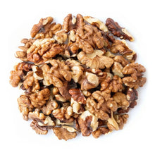 Raw walnut halves and pieces pile in assorted light and dark brown tones