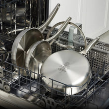 Triply stainless steel cookware pieces stacked in dishwasher rack, lids on
