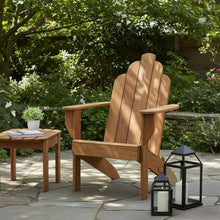 Teak Adirondack chair with tall slatted back, curved armrests, and wide seat