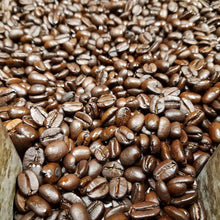 Light roast whole coffee beans, glossy medium-brown with visible cracks