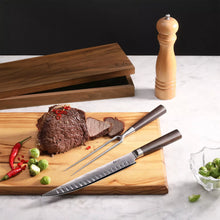 Carving knife and fork with dark wooden handles on wooden board; wooden storage box