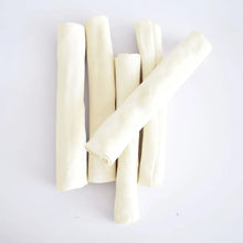 Beef hide chew sticks, light ivory, laid out in a small group