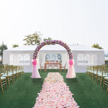 White pop-up canopy tent with windowed side panels and arched floral wedding setup