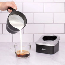 Capresso Automatic Milk Frother pouring milk from the spout into a cup