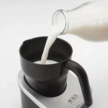 Capresso Automatic Milk Frother pouring milk into black frothing pitcher