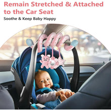 Pink piggy spiral plush toy attached to a car seat, with mirror ring in center