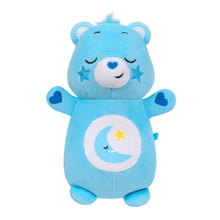 Blue plush bear toy with sleepy face, moon emblem on belly, and soft heart accents