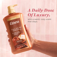 Brown body wash bottle with gold pump, Caress label held in hand