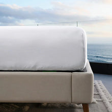 White bed sheet on sofa bed with neatly folded top
