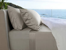 Cream bed sheet set draped over sofa bed with matching pillowcases
