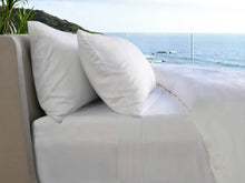 White bed sheet set with two pillows on sofa bed