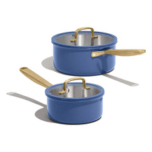 Blue tri-ply stainless saucepan set with two matching lids and gold handles, stacked