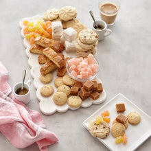 Assorted Viennese whirls and chocolate pieces on a white platter with cups