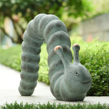 Garden caterpillar statue on patio, head raised with copper-tipped antennae, green finish
