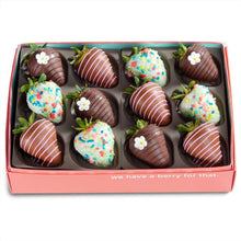 Chocolate-covered strawberries assortment in a gift box, with white stripes, sprinkles, and leaves
