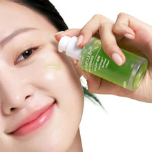 Noni ampoule serum bottle with dropper, held near the face