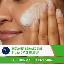 Travel-size cream-to-foam facial cleanser with white foam on face and fingers