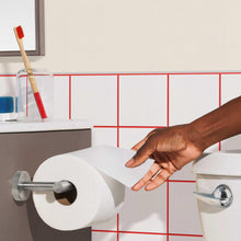Bath tissue roll in holder with hand reaching, Charmin Ultra Strong bath tissue