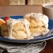 Sausage gravy on split biscuits in a dish, with thick white gravy topping.