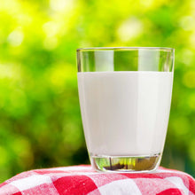 Glass of white milk on red-and-white check cloth