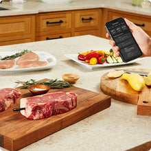Chef iQ smart thermometer app on phone while prepping raw meat and vegetables