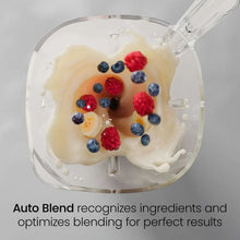 Ice-crushing blender jar with berries and creamy ice blend visible from above