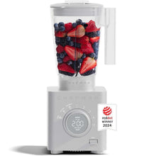 Ice-crushing blender with clear jar filled with mixed berries and sliced fruit