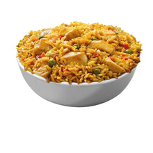 Chicken fried rice in a white bowl with sliced chicken and green peas