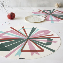 Round woven placemat with multicolor bowburst geometric pattern, laid flat on table