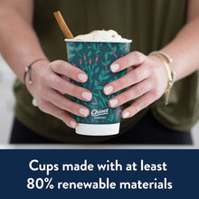 Insulated 16 oz cup with black lid, drink in hands; green berry pattern sleeve.