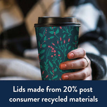Insulated 16 oz cup with black lid held in hand; green berry pattern sleeve.