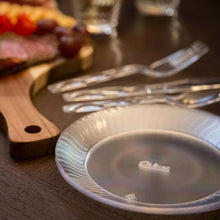 Clear plastic 7 in dessert plate on table, ridged rim visible