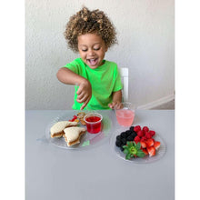 Clear plastic dinner plate with ridged rim on tabletop for snacks