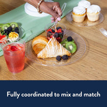 Clear plastic dinner plate with ridged rim holding pastries and fruit