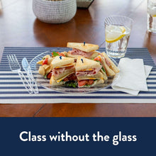 Clear plastic dinner plate with ridged rim holding assorted sandwiches