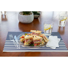 Clear plastic dinner plate with ridged rim holding sandwich assortment