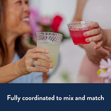 Crystal plastic cups in hands, one clear and one red drink