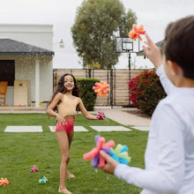 Colorful reusable sponge balls held by children, foam flower shapes.