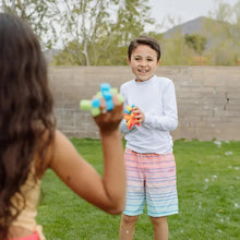 Colorful reusable sponge ball in a child’s hands during outdoor play.