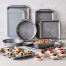 Grey nonstick bakeware set with multiple pans and a round skillet, stacked for storage