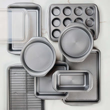 Grey nonstick bakeware set contents: baking sheets, square pan, round pan, and loaf pan