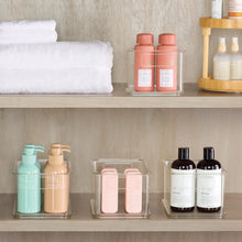 Clear plastic organizer bins with hinged lids for storing bottles and jars
