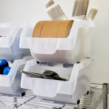 White stacking storage bins close-up: top compartment holds a brown roll and utensils.