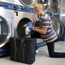Black foldable laundry caddy with wide opening and front pocket strap