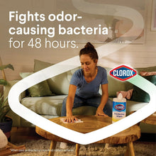 Clorox disinfecting wipes canister with wipe being used on a surface, fresh scent