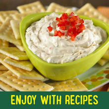 Snack crackers with creamy dip in a green bowl and red garnish