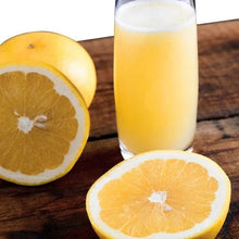 Grapefruit halves and glass of citrus juice on wooden surface