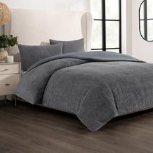 Gray bouclé comforter and pillow shams set on a bed, textured fabric