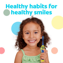 Kids extra-soft toothbrush held in hand, blue and yellow handle with bristles